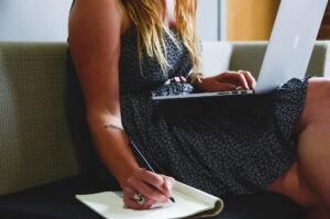 Morning Prayers For Entrepreneurs: Entrepreneur writing goals in a journal with a calm expression